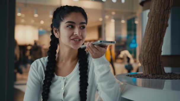 Nuori arabialainen nainen tyttö shopper lähettää ääniviestin äänitiedosto puhe kaiuttimella aktivoi ääni app käyttää ai apua naispuolinen liikenainen puhua puhelin solu yhteys kommunikoi verkossa - Materiaali, video