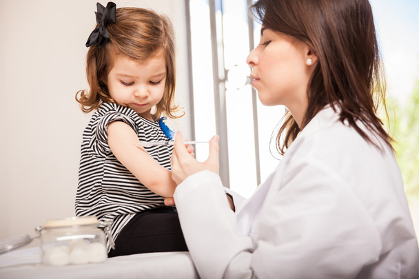 Pediatrician giving a girl a shot - Photo, Image