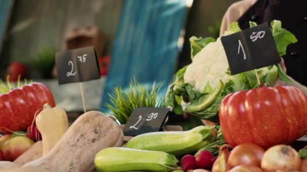 顧客のためのカリフラワー製品を保持する女性の八百屋は、カードや葉で有機バイオ製品を販売しています。新鮮な自然野菜を示すエプロン付きの農民市場の売り手。閉じろ!. - 映像、動画