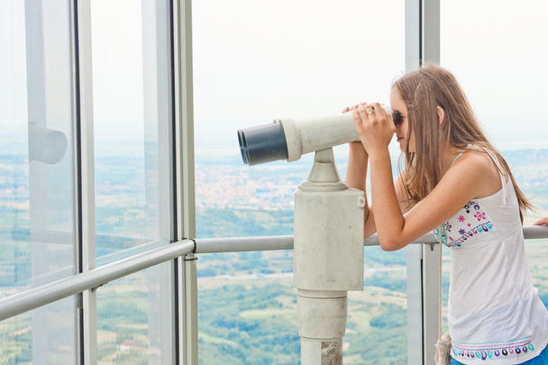 Дівчина дивиться через туристичний телескоп
 - Фото, зображення