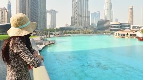 Beautiful young caucasian woman tourist enjoys panoramic view from marina pools in downtown Dubai. Travel visit dubai concept. Low angle banner shot - Footage, Video