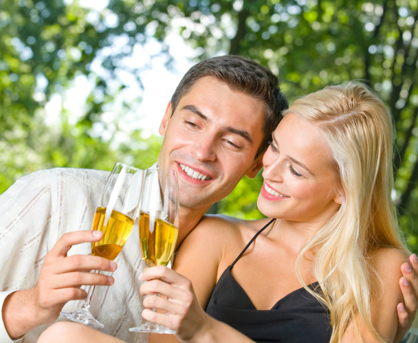 Young happy couple celebrating with champagne, outdoors - Foto, Imagen