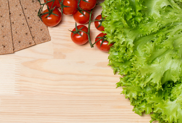 lettuce, tomatoes and rye bread on wooden background - Фото, зображення