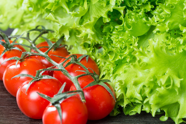 Salaatti ja tomaatit puupohjalla
 - Valokuva, kuva