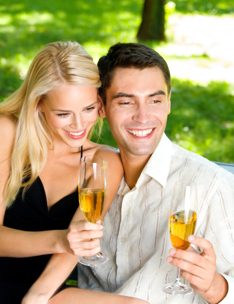 Młoda para obchodzi z szampanem razem, na zewnątrz - Zdjęcie, obraz