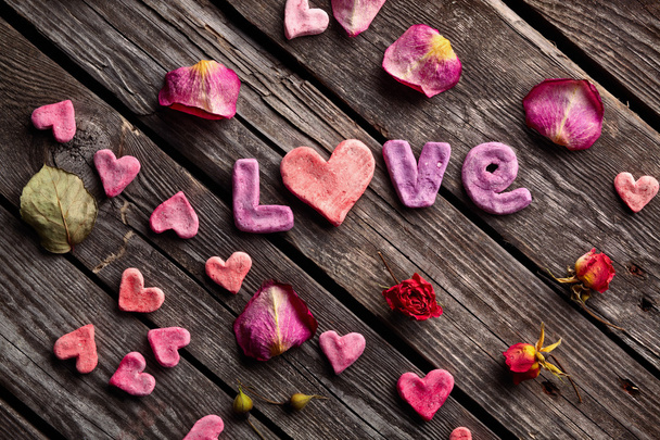 Palabra Amor con pétalos de rosa
 - Foto, imagen