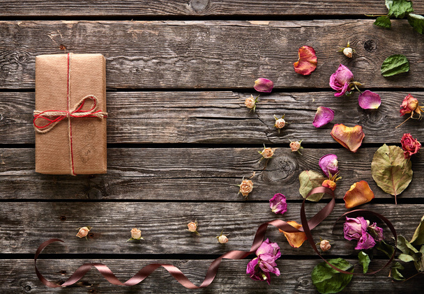 Συσκευασία δώρου με ροδοπέταλα και αποξηραμένα λουλούδια - Φωτογραφία, εικόνα