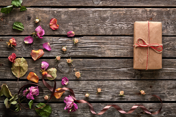 Συσκευασία δώρου με ροδοπέταλα και αποξηραμένα λουλούδια - Φωτογραφία, εικόνα