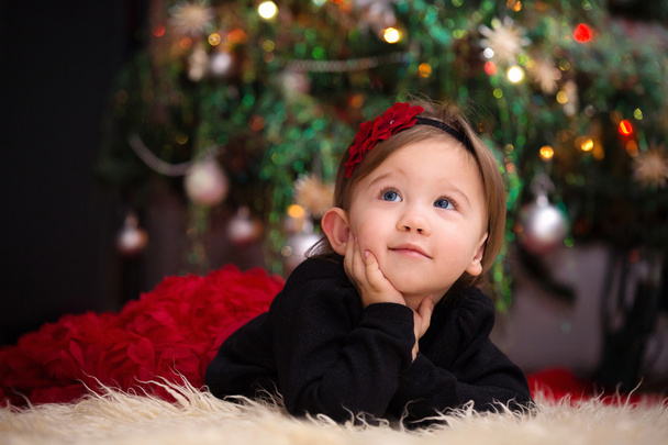Baby Girl Under Christmas Tree - 写真・画像