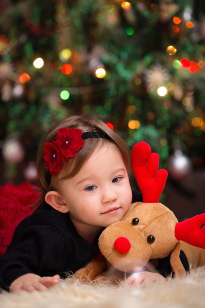 Bebé niña bajo el árbol de Navidad
 - Foto, imagen
