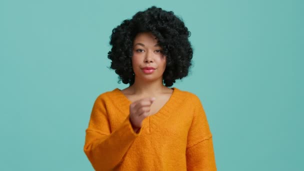 Studio al rallentatore girato splendida donna afroamericana in maglione arancione brillante guardando dritto nella fotocamera e mostrando zip, chiusura bocca gesto visualizzazione silenzio, stop non voglio parlare - Filmati, video