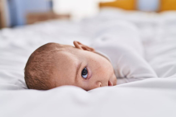 Adorable baby relaxed lying on bed at bedroom - Φωτογραφία, εικόνα