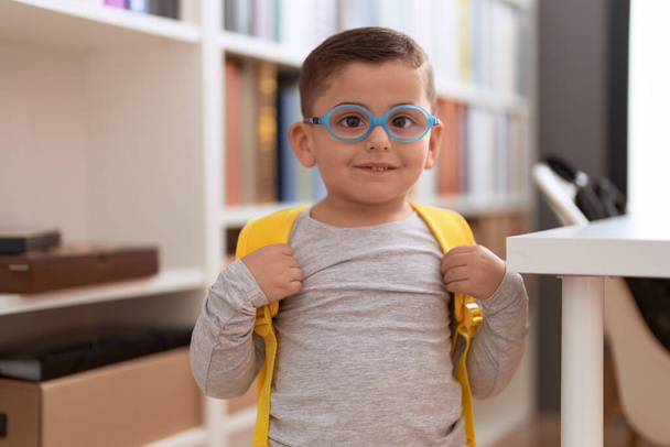 Adorável estudante hispânico criança sorrindo confiante em pé na biblioteca escola - Foto, Imagem