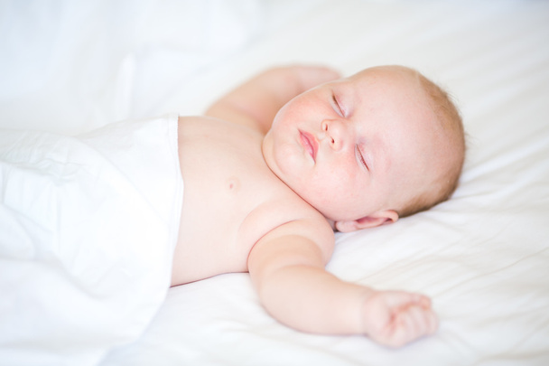 Peaceful newborn baby lying on a bed sleeping - Foto, imagen