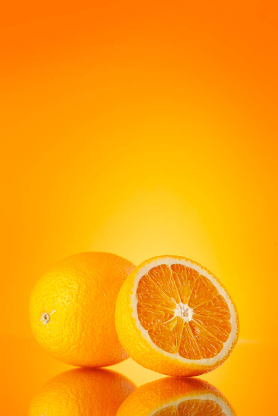 Friss narancssárga gyümölcsök narancssárga háttérrel és másoló hellyel - Fotó, kép