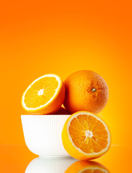 コピースペース付きオレンジの背景に新鮮なオレンジ色の果物 - 写真・画像
