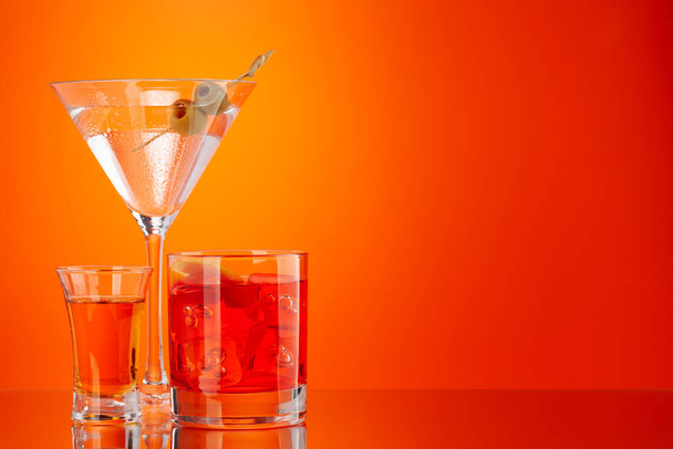 Выстрел и негрони и мартини коктейль на оранжевом фоне - Фото, изображение