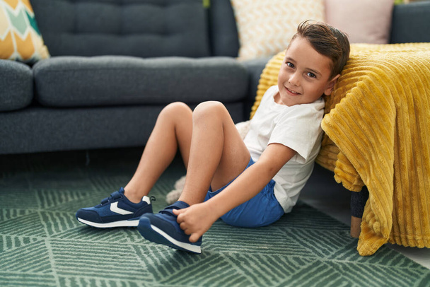 Suloinen latino lapsi hymyilee luottavainen istuu lattialla kotona - Valokuva, kuva
