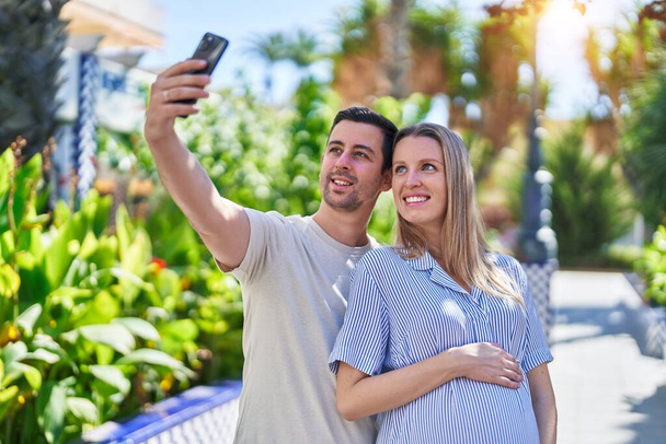 Άνδρες και γυναίκες ζευγάρι περιμένουν μωρό κάνουν selfie από το smartphone στο πάρκο - Φωτογραφία, εικόνα