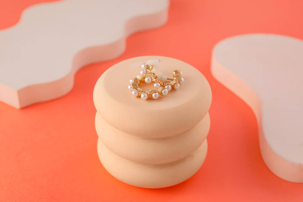 Soporte con hermosos pendientes de perlas en el fondo de color - Foto, Imagen