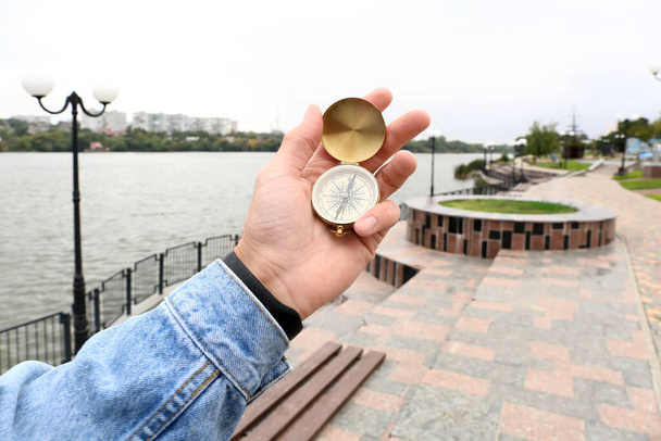Hombre con brújula dorada en el parque, primer plano - Foto, imagen