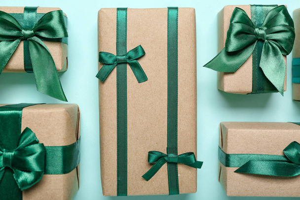 Verschiedene Geschenkboxen mit schönen grünen Band auf farbigem Hintergrund gebunden, Nahaufnahme - Foto, Bild