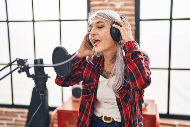 Keski-ikä harmaa tukka nainen taiteilija laulaa laulun musiikkistudiossa - Valokuva, kuva