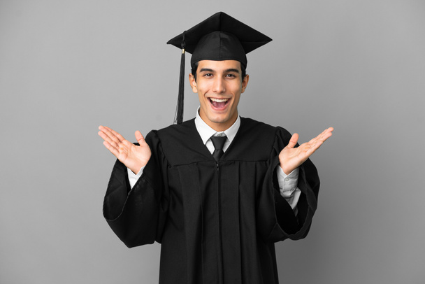 Young Argentinian university graduate isolated on grey background with shocked facial expression - Photo, Image