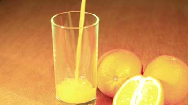 Orangen und Saft, der in Glas gegossen wird - Filmmaterial, Video