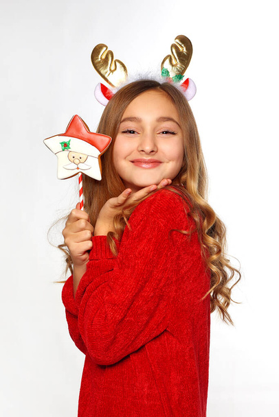 szczęśliwa dziewczyna w kostiumie jelenia Boże Narodzenie stoi odizolowany nad białym tle ściany. Patrzę w kamerę. - Zdjęcie, obraz