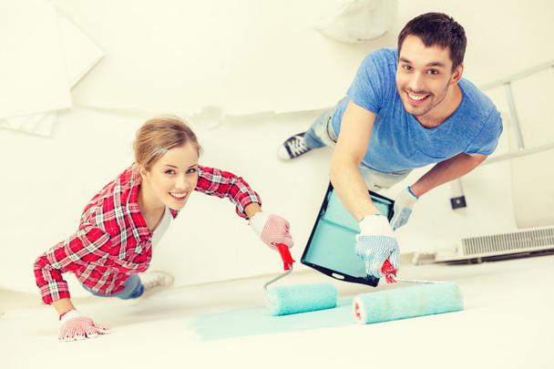 smiling couple painting wall at home - Foto, Imagem