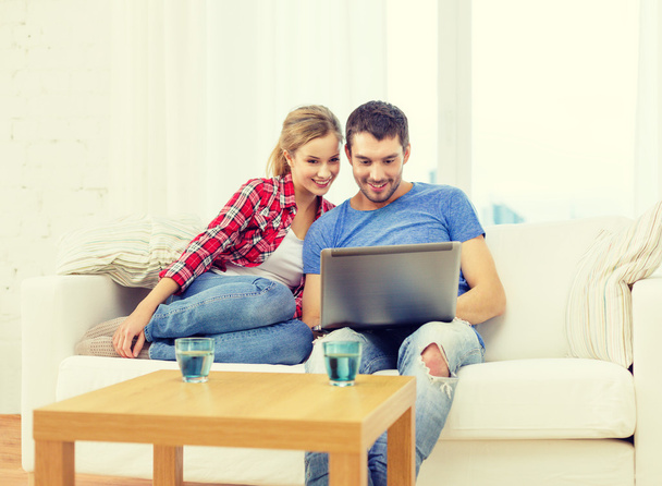 smiling couple with laptop computer at home - Photo, Image