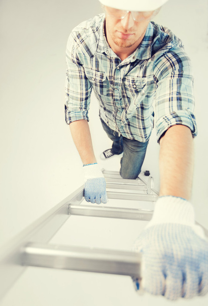 man in helmet and gloves climbing ladder - Φωτογραφία, εικόνα