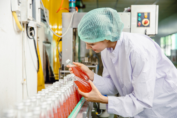 Mitarbeiter der Lebensmittel- und Getränkeindustrie arbeiten an der Bandmaschine in einer Getränkefabrik mit Reinigungs- und Hygienebereich. - Foto, Bild