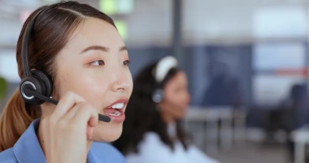 Hívóközpont, ügyfélszolgálat és értékesítés egy ázsiai női tanácsadóval, aki egy fülhallgatón dolgozik az irodájában. Lépjen kapcsolatba velünk, e-kereskedelem és kiskereskedelem egy női munkavállaló tanácsadás egy hívást a munkahelyen. - Felvétel, videó