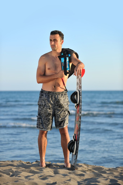 Portrait of a young kitsurf man at beach on sunset - Fotó, kép