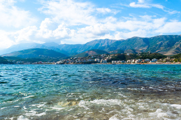 Beautiful summer cloud landscape of beach town of Himare at foot of  mountains on border of Ionian and Adriatic seas. Albania. Concept of summer holidays and relaxation. - Photo, Image