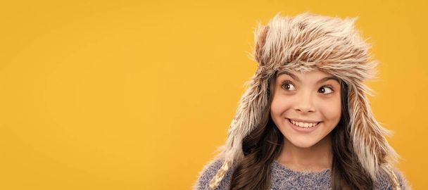 express positive emotion. winter fashion. happy kid with curly hair in earflap hat. Child face, horizontal poster, teenager girl isolated portrait, banner with copy space - Foto, afbeelding
