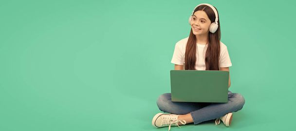 счастливая девочка использовать беспроводной ноутбук для видеозвонков или слушать веб-бинар в наушниках, обратно в школу. - Фото, изображение