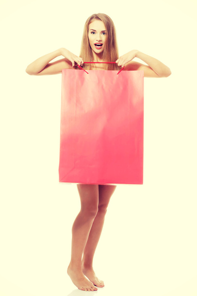 Naked beautiful woman holding shoping bag. - Foto, imagen