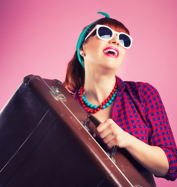Pin-up girl posing with vintage suitcase - 写真・画像