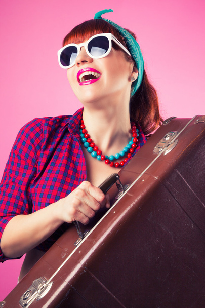 Pin-up girl posing with vintage suitcase - 写真・画像