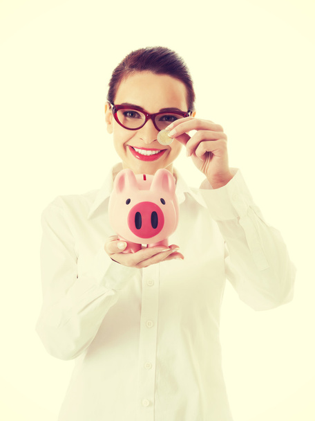 Business woman with coin and piggy- bank. - 写真・画像