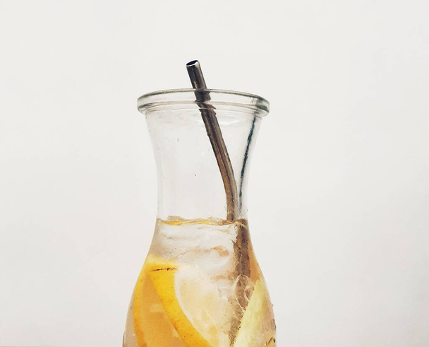Boisson glacée au citron et citronnelle, très rafraîchissante. Servi dans une bouteille en verre longue attrayante, avec une paille en acier inoxydable respectueux de l'environnement. - Photo, image