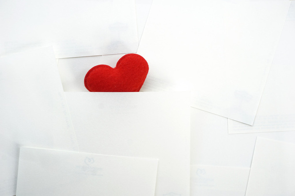 Corazón rojo oculto sobre fondo de papel blanco
 - Foto, Imagen