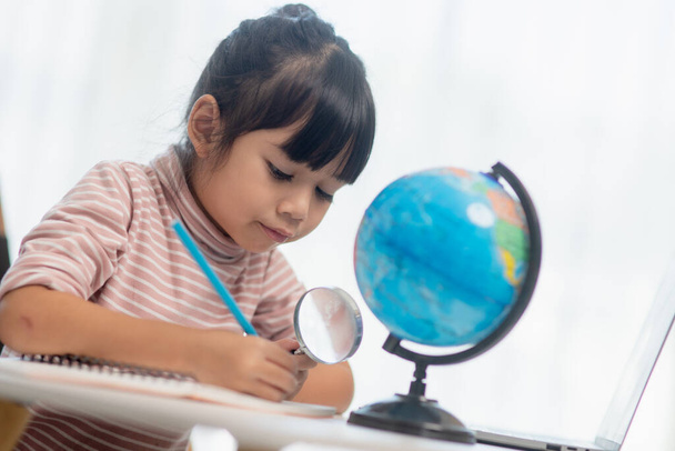 Menina asiática está aprendendo o modelo globo, conceito de salvar o mundo e aprender através de atividade lúdica para a educação infantil em casa. - Foto, Imagem
