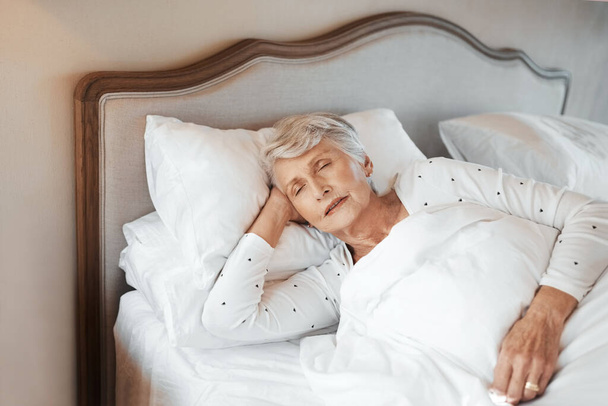 O sono é vital para a saúde geral. uma mulher idosa dormindo na cama em um lar de idosos - Foto, Imagem