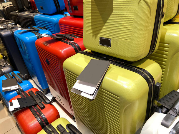 muchas maletas modernas de colores diferentes, conjunto de maletas con etiquetas de precios en la tienda, pila de maletas de viaje nuevas maletas apiladas, fondo - Foto, Imagen