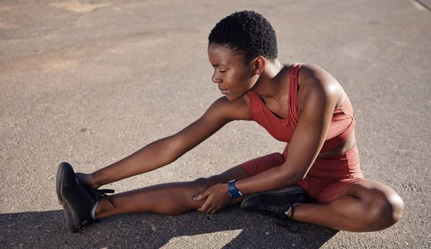 Black woman, fitness or stretching legs on city street for muscle pain relief, healthcare wellness or body tension. Runner, sports athlete or person in warm up exercise, workout or training on road. - Photo, Image