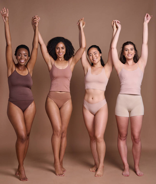 A nők sokfélesége, a test pozitivitása és a bőr színének ünneplése modellbarátok csoportja fogja egymás kezét. Skincare szépség, bizalom és a nők közösségi támogatás portré együtt globális ellátás és a szeretet. - Fotó, kép